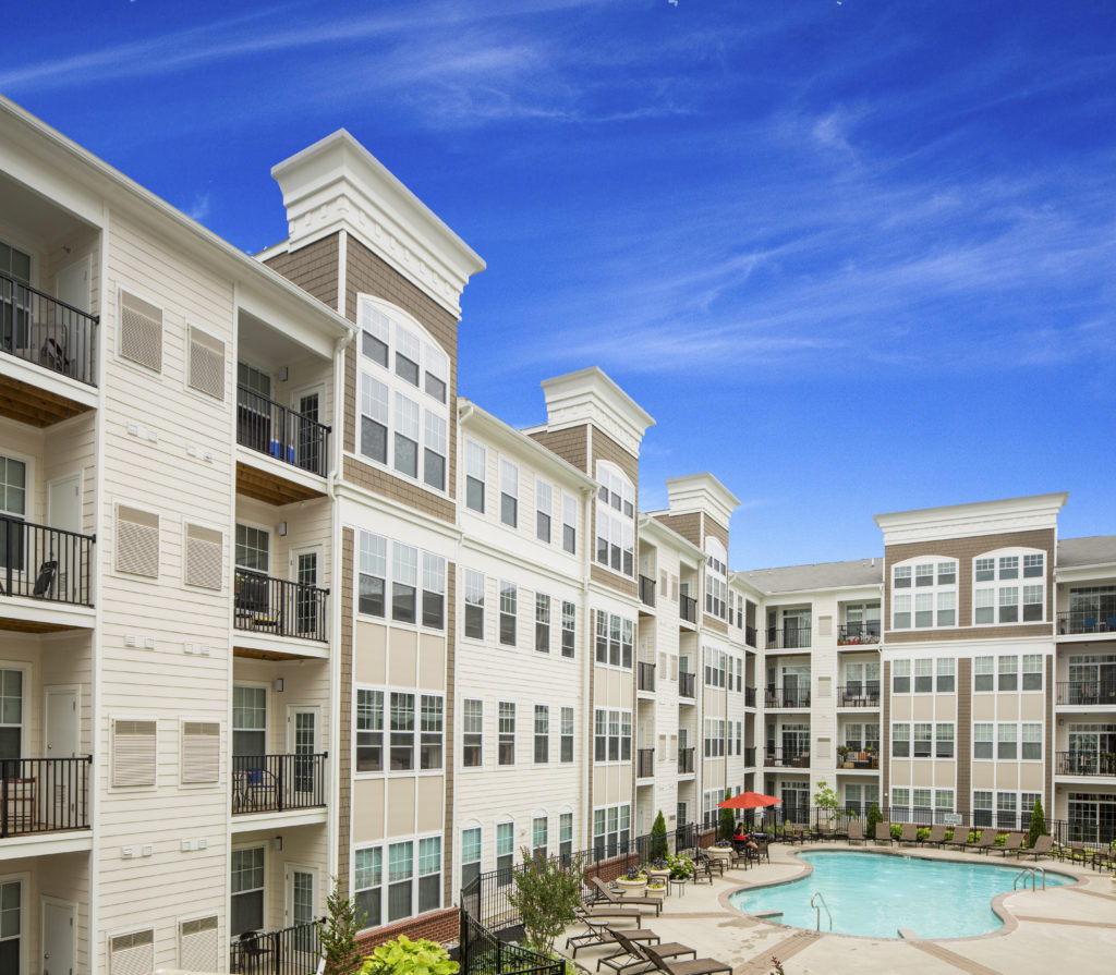 Buildings with apartment balconies and community outdoor pool with lounges