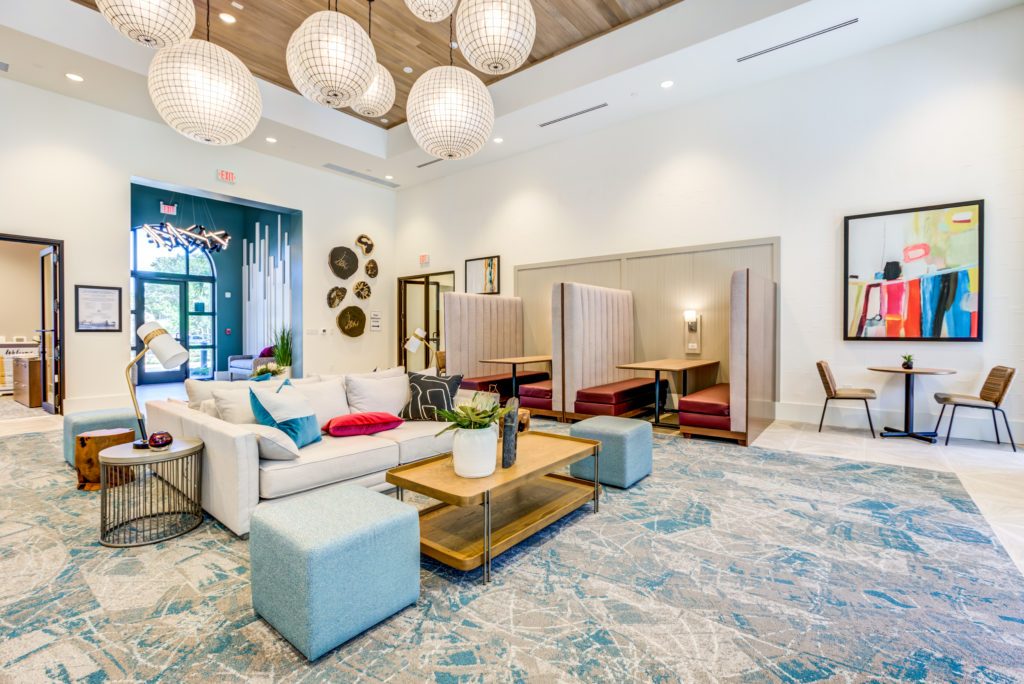 Community clubroom with lounge and booth seating at The Point at Palm Beach Gardens