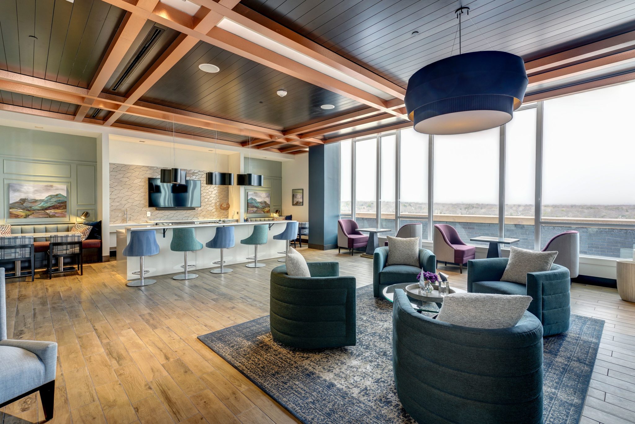 Clubroom at The Point at Ridgeline with bar seating, lounge chairs and adjacent deck area