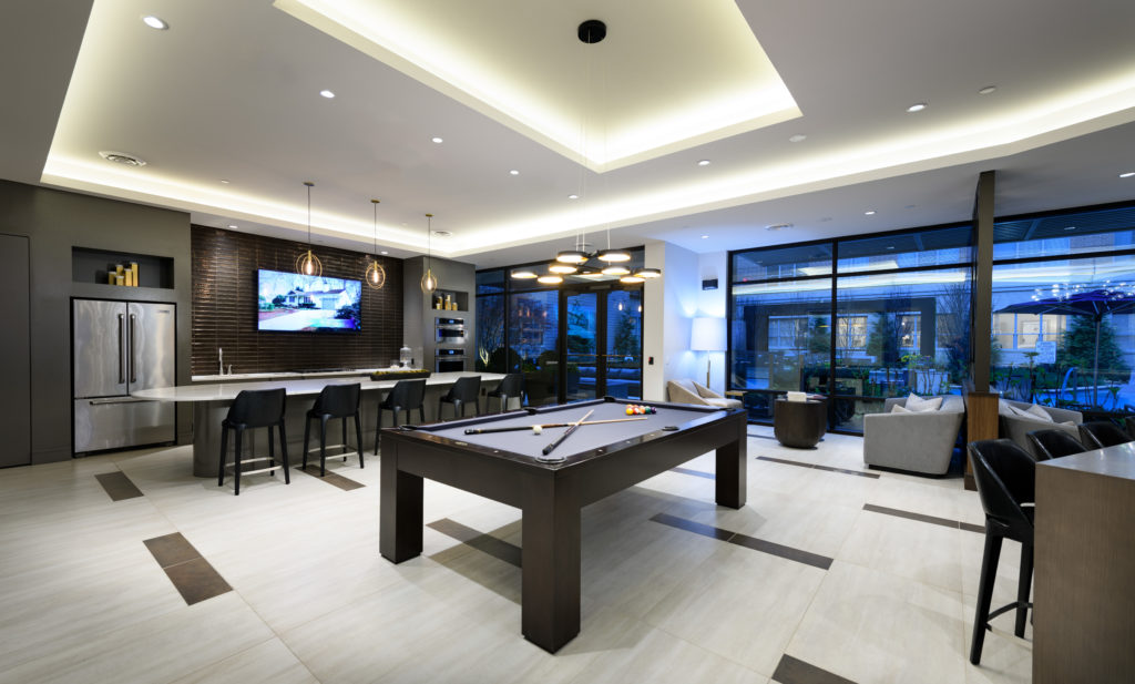 Clubroom at The Point at Exton with pool table, community kitchen and adjacent outdoor courtyard