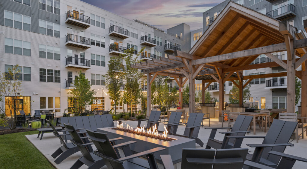 Outdoor courtyard with firepit, lounge chairs and outdoor dining area at The Point at Green District.