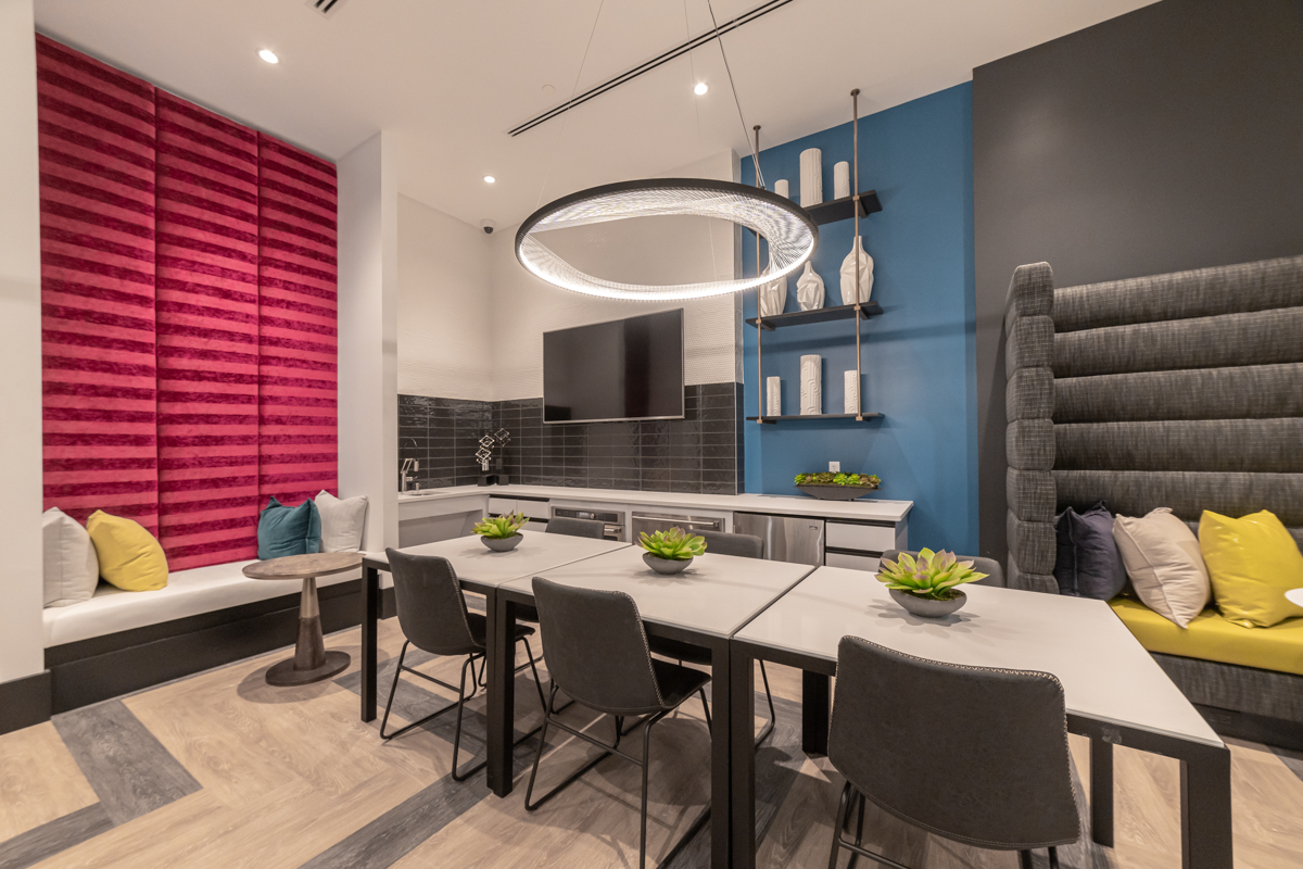 Community room with kitchen area, television, table and seating at The Point at Falls Church