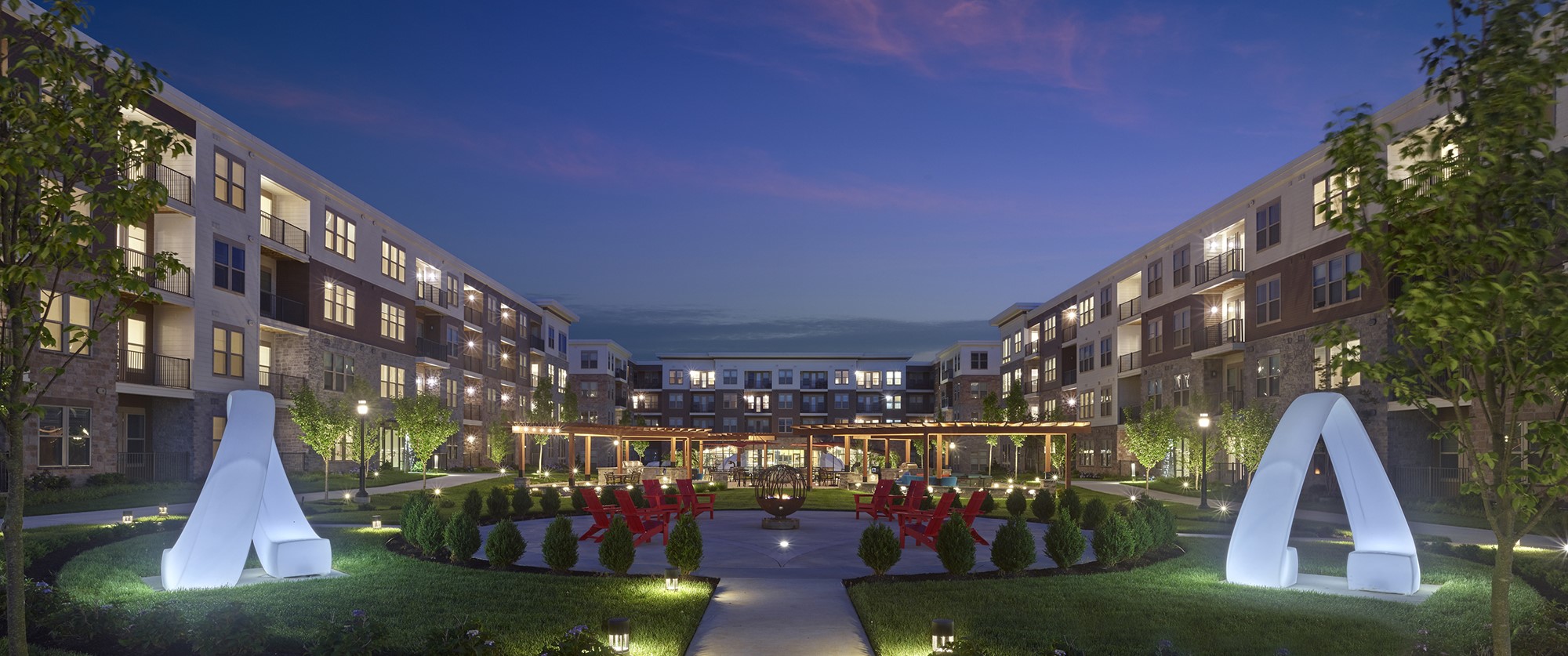 Large outdoor courtyard with art sculptures and seating at The Point at Downingtown